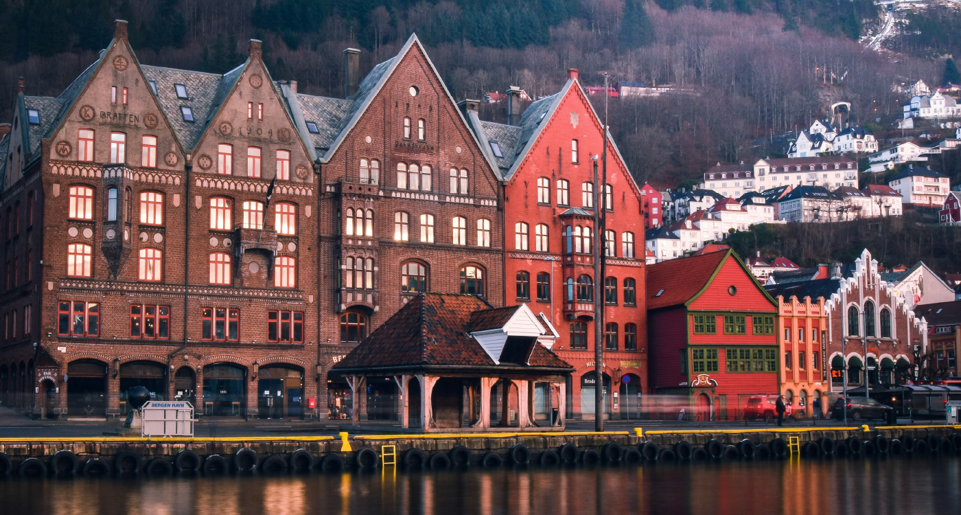 Bygninger i brunt og roedt som ligger ved vannet.